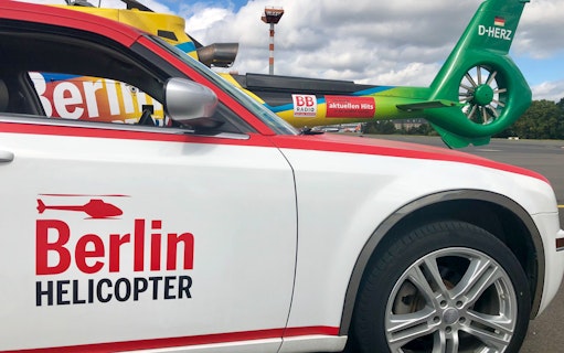Berlin helicopter and car on tarmac, related to Candle Flight Dinner tour.