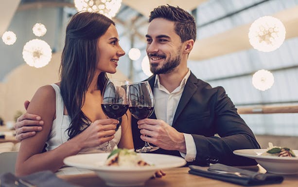 Couple enjoying a romantic Candle Flight Dinner with wine.