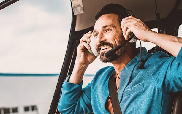 Man wearing headset in helicopter during Rundflug Berlin Brandenburg tour.