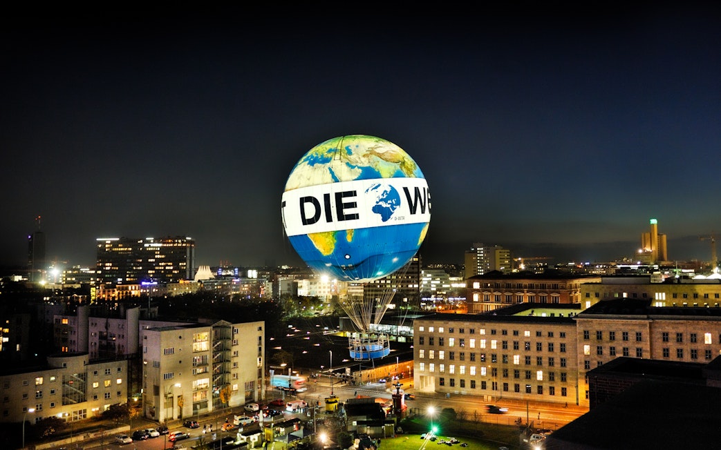 Hot air balloon over Berlin cityscape at night, Aufstieg mit dem Weltballon experience.