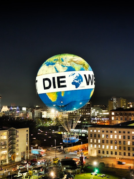 Hot air balloon over Berlin cityscape at night, Aufstieg mit dem Weltballon experience.