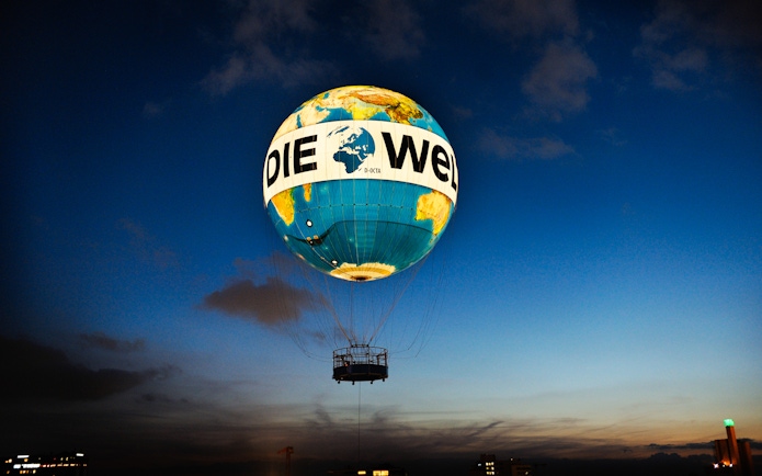 Hot air balloon ascent with "Die Welt" design at dusk, Berlin.