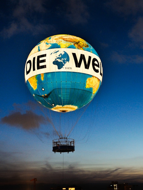 Hot air balloon ascent with "Die Welt" design at dusk, Berlin.