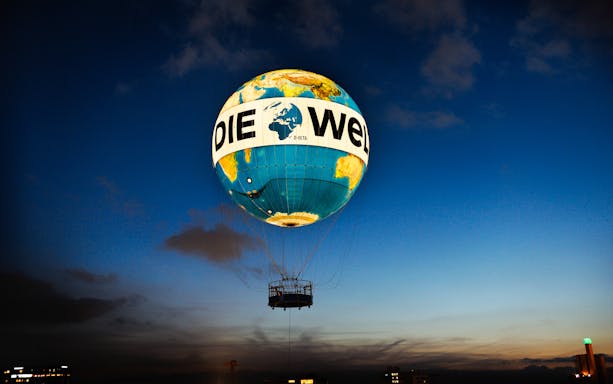 Hot air balloon ascent with "Die Welt" design at dusk, Berlin.