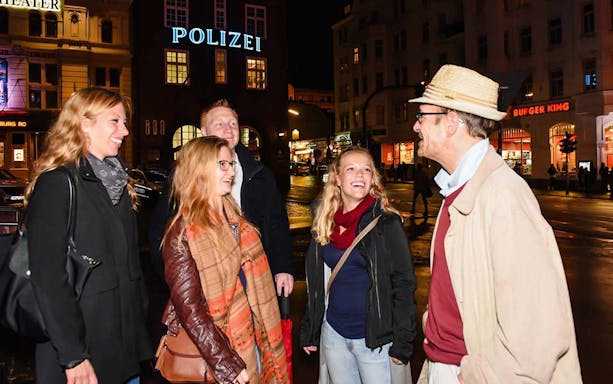 Tour group enjoying a night walk on the Reeperbahn in Hamburg's red light district.