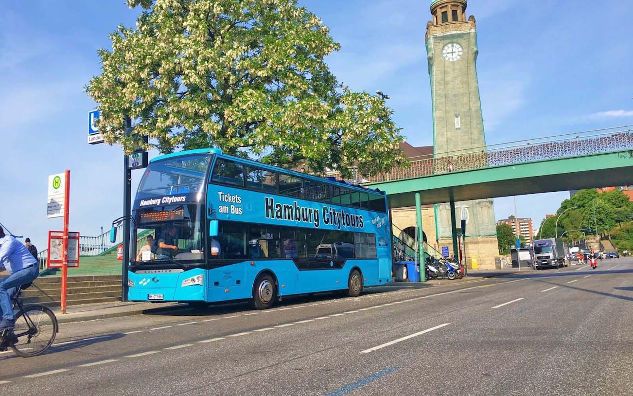Hamburg city tour bus parked near clock tower on Reeperbahn tour route.
