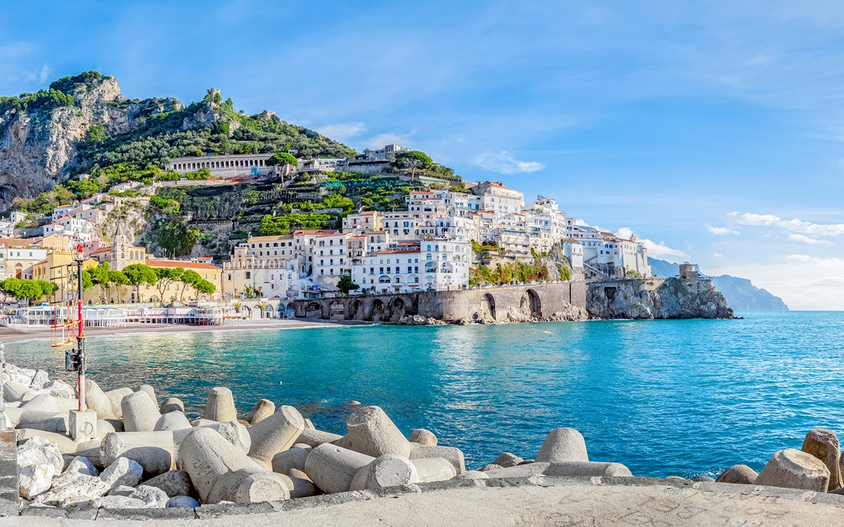 Positano coastline with colorful hillside buildings and clear blue sea, part of Amalfi tour.