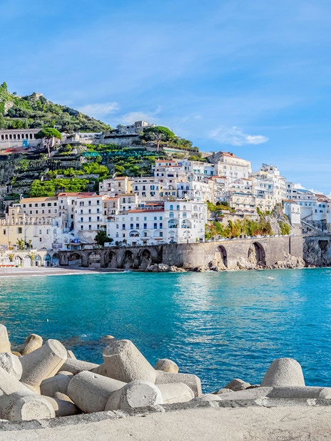 Positano coastline with colorful hillside buildings and clear blue sea, part of Amalfi tour.