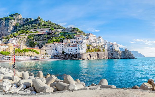 Positano coastline with colorful hillside buildings and clear blue sea, part of Amalfi tour.