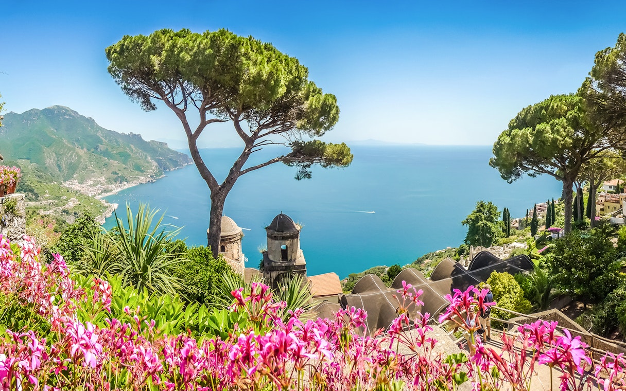 View of the Amalfi Coast from Ravello with vibrant flowers and Mediterranean Sea.