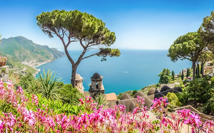 View of the Amalfi Coast from Ravello with vibrant flowers and Mediterranean Sea.