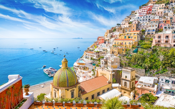 Positano coastline with colorful buildings and dome, view from Amalfi tour.