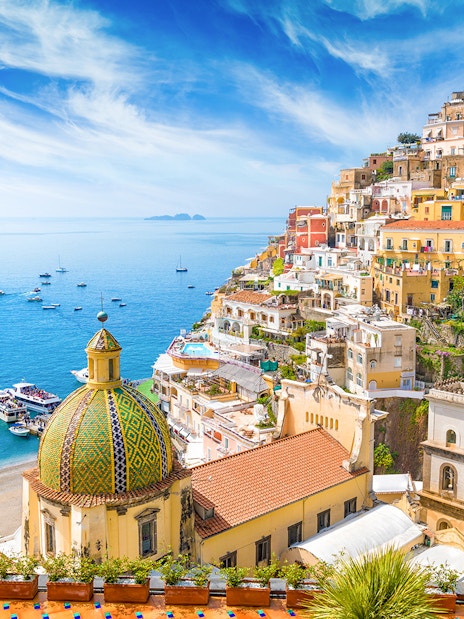 Positano coastline with colorful buildings and dome, view from Amalfi tour.
