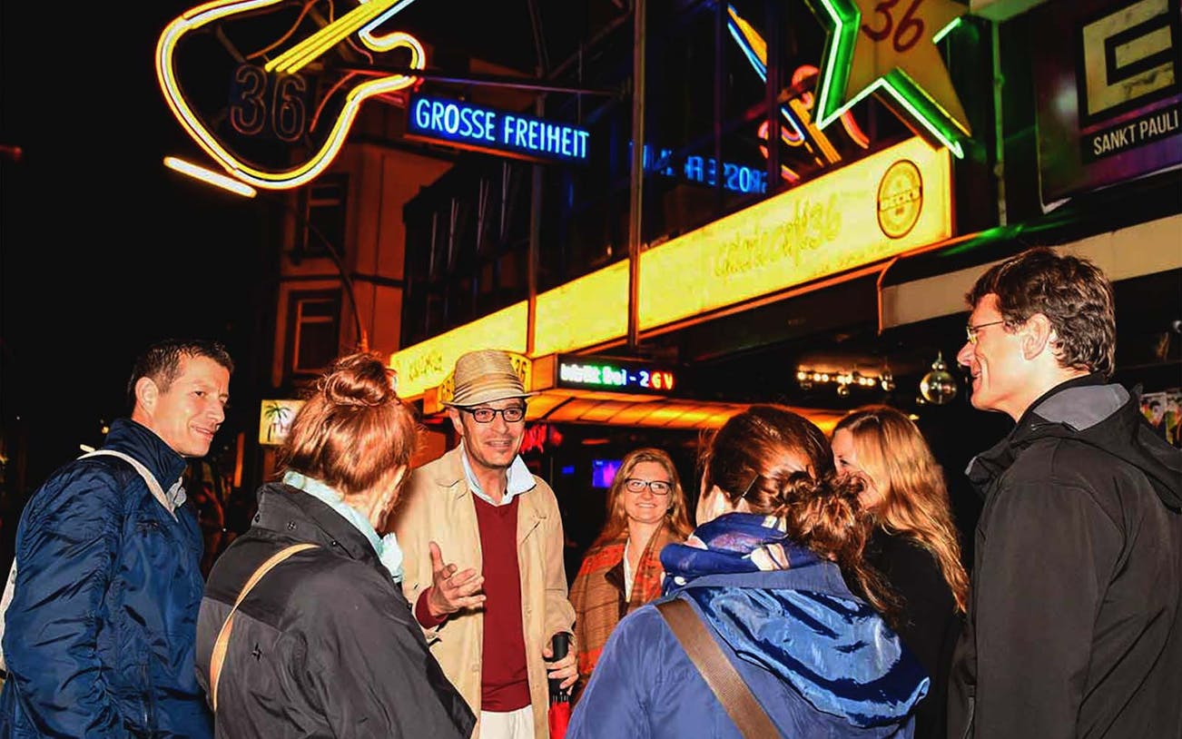 Group on a guided tour in St. Pauli's red light district, Hamburg, at night.
