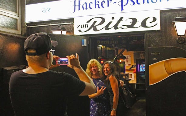 Visitors posing for a photo outside Zur Ritze bar in St. Pauli, Hamburg during a guided tour.