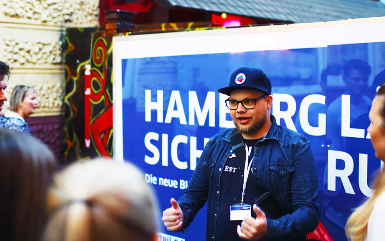 Guide leading a St. Pauli Highlights tour in Hamburg, engaging with a group.