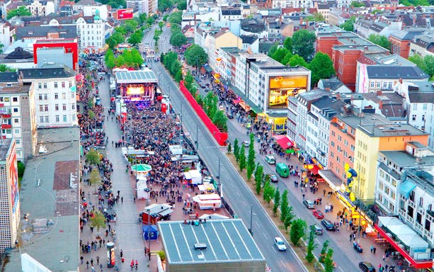 Aerial view of a bustling street festival in St. Pauli, Hamburg, with crowds and a stage.