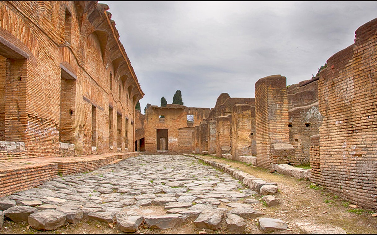Ancient Roman ruins with stone pathway at Ostia Archaeological Park, Italy.