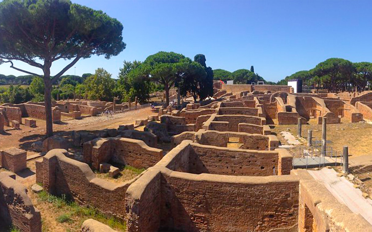 Ancient ruins and trees at Ostia Archaeological Park, Italy.
