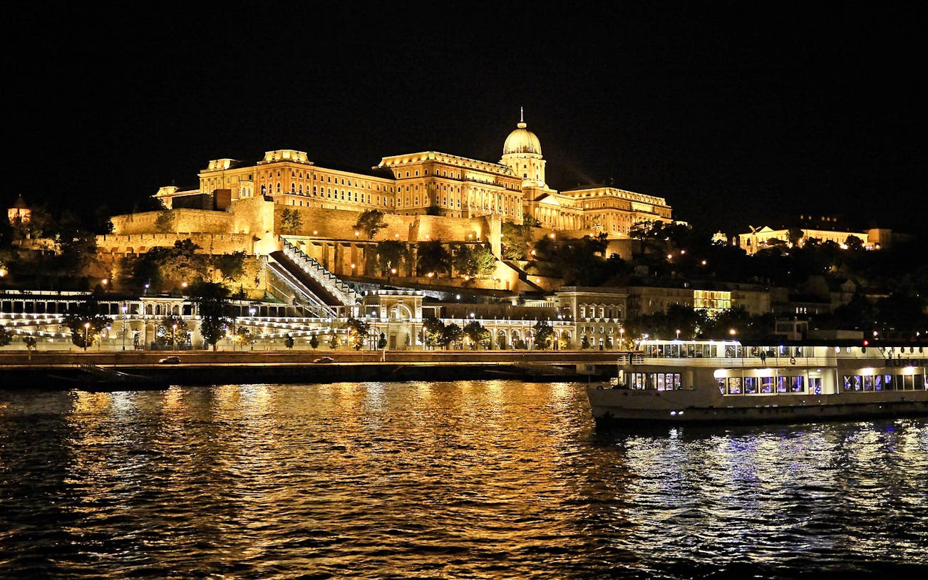 Night view of Buda Castle from a River Danube sightseeing cruise in Budapest.