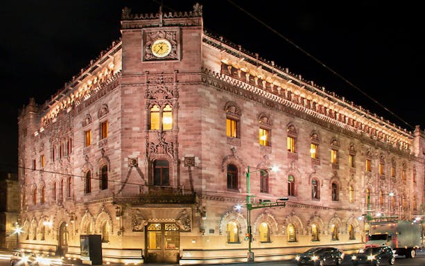 Historic building illuminated at night in Mexico City during the night tour.