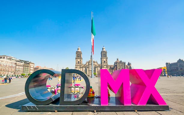 Mexico City Zócalo with CDMX sign and Metropolitan Cathedral in background.