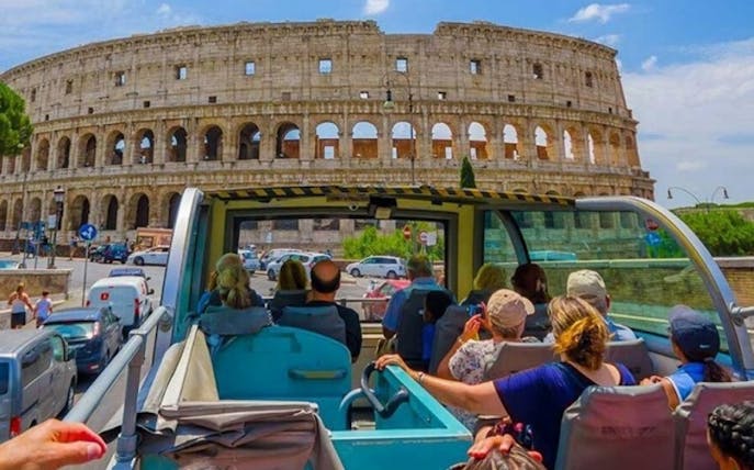 Open-top bus tour near the Colosseum in Rome.