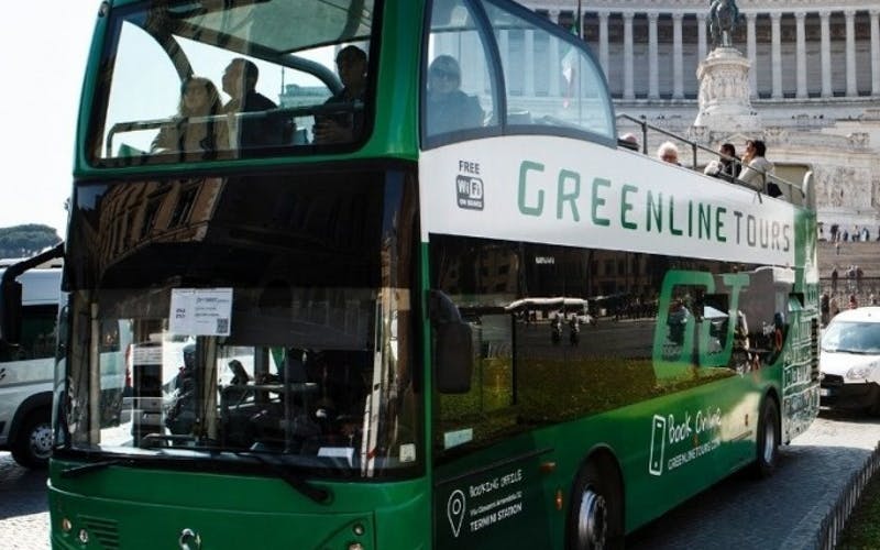 Green double-decker tour bus in front of Rome's Altare della Patria.