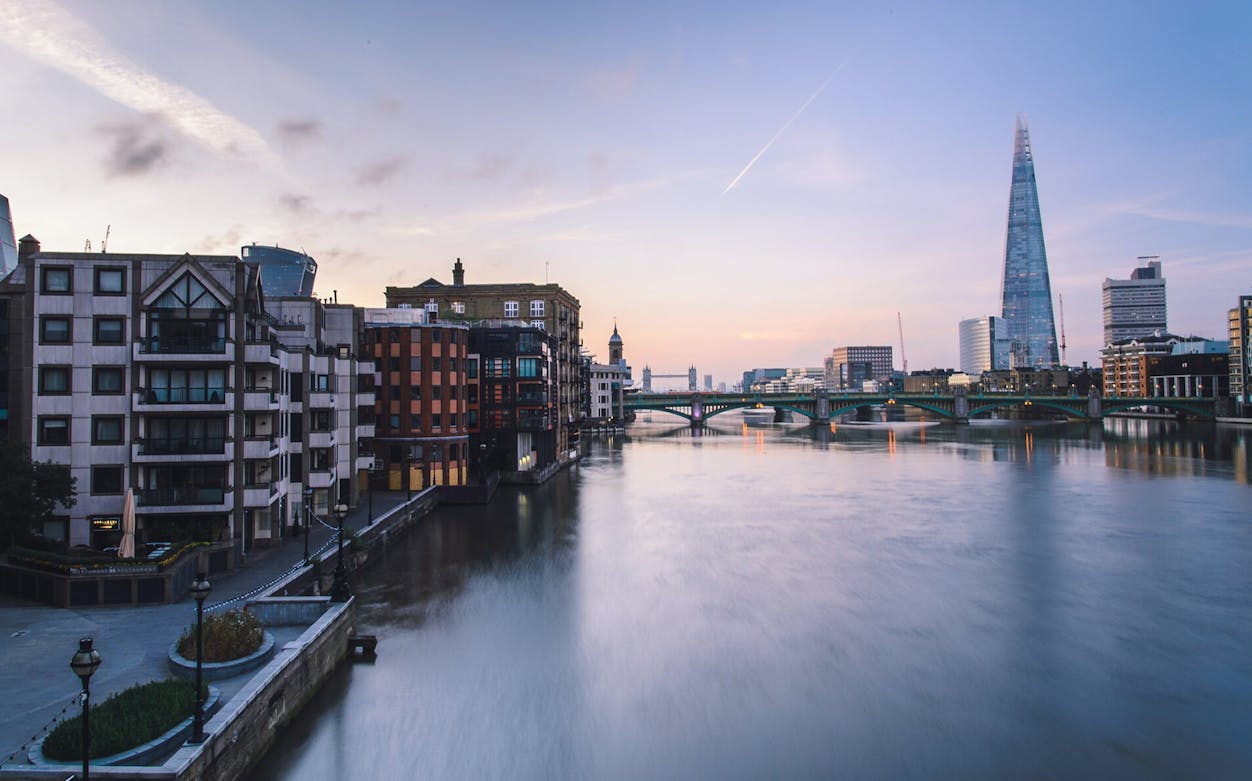 River Thames view with The Shard and Southwark Bridge in London at sunset.
