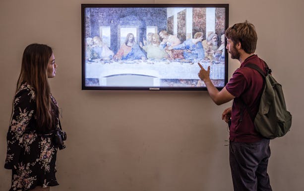 Visitors viewing Da Vinci's Last Supper on a guided tour in Milan.