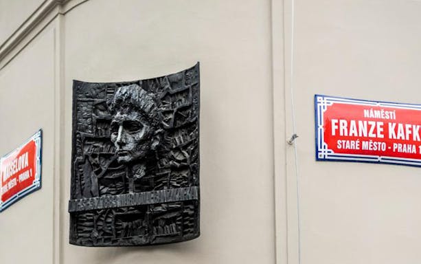 Franz Kafka relief sculpture on a wall in Prague's Old Town.