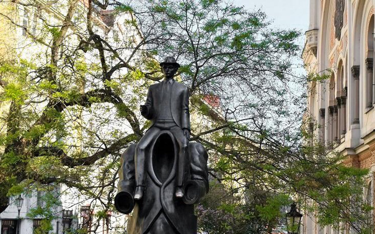 Franz Kafka statue in Prague, featuring a headless figure carrying Kafka, part of the 2.5-hour tour.