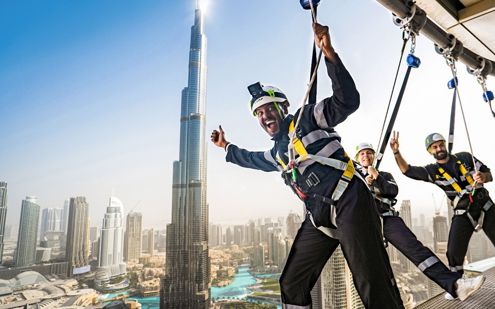 Participants on the Edge Walk at Sky Views Dubai with Burj Khalifa in the background.