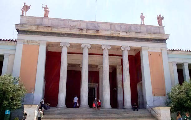 Entrance of the National Archaeological Museum in Athens with columns and statues.