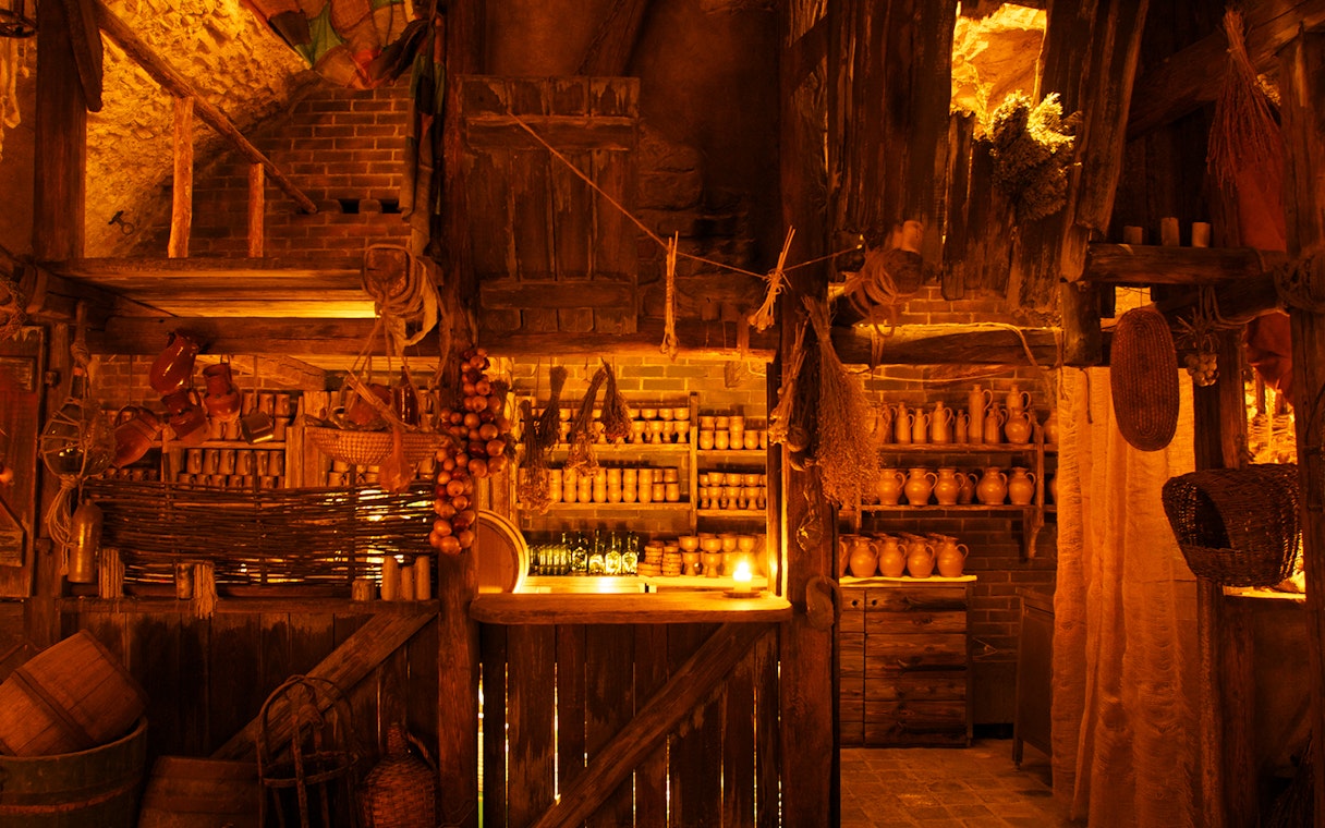 Medieval tavern interior with rustic decor and pottery for New Year's Eve dinner.