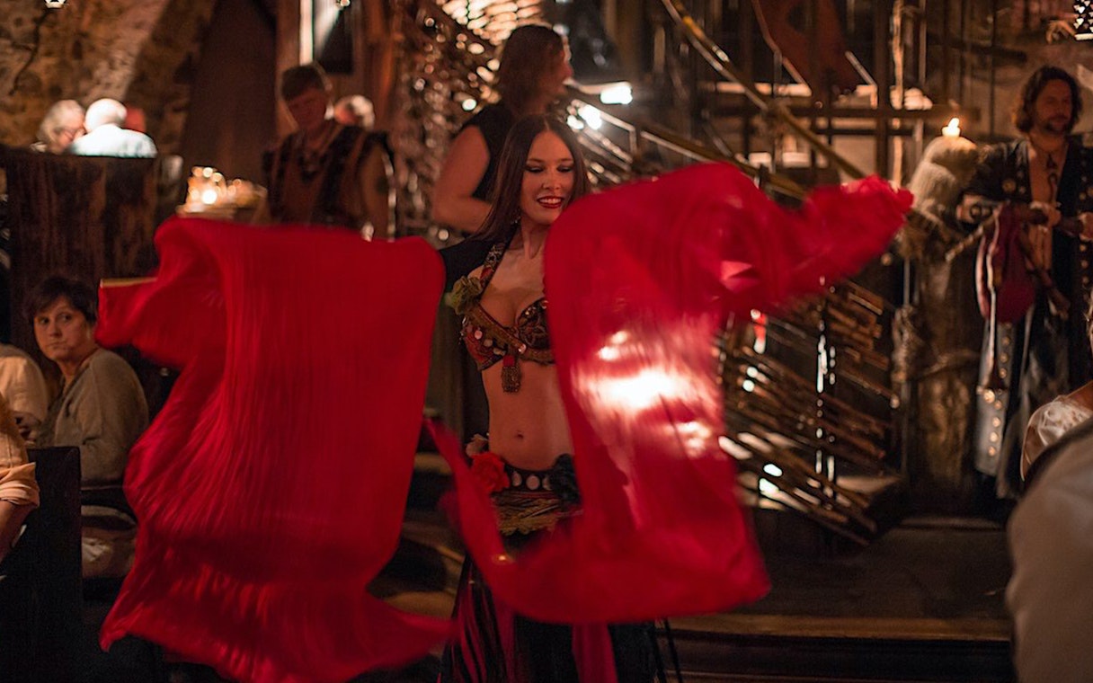 Dancer performing with red veils at a medieval New Year's Eve dinner.