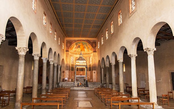 Interior of the Basilica of San Giorgio in Velabro, Rome, with ancient columns and frescoed apse.