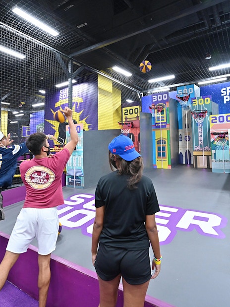 Visitors playing basketball game at SuperPark Singapore indoor activity center.