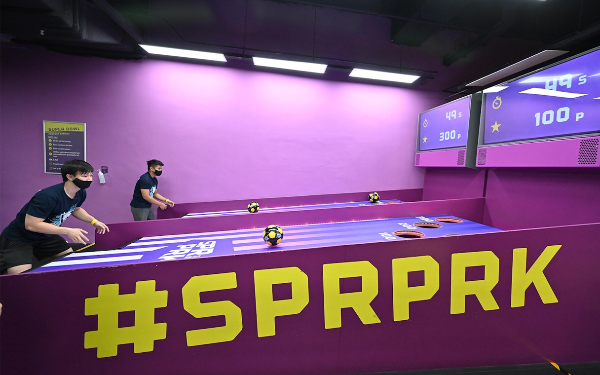 Visitors playing a ball game at SuperPark Singapore indoor activity center.