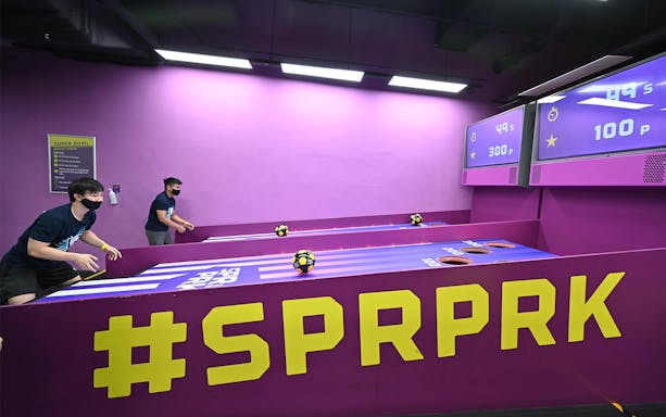 Visitors playing a ball game at SuperPark Singapore indoor activity center.