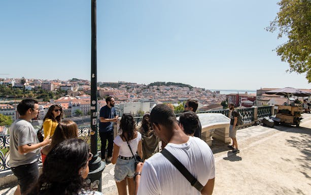 Group of tourists on a Lisbon walking tour overlooking the cityscape.