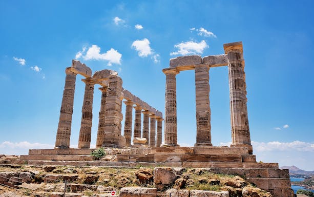 Temple of Poseidon at Cape Sounion with clear blue sky.