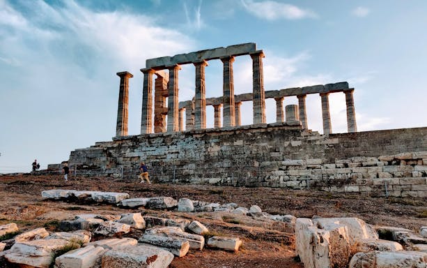 Temple of Poseidon at Cape Sounion with visitors exploring the ancient ruins.