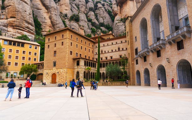 Montserrat Monastery courtyard with tourists in Barcelona, Spain.