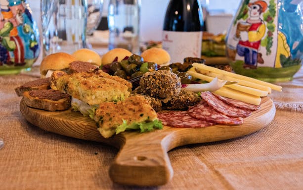 Assorted brunch platter with cheeses, meats, and bread, paired with wine in the lands of Frederik II of Swabia.