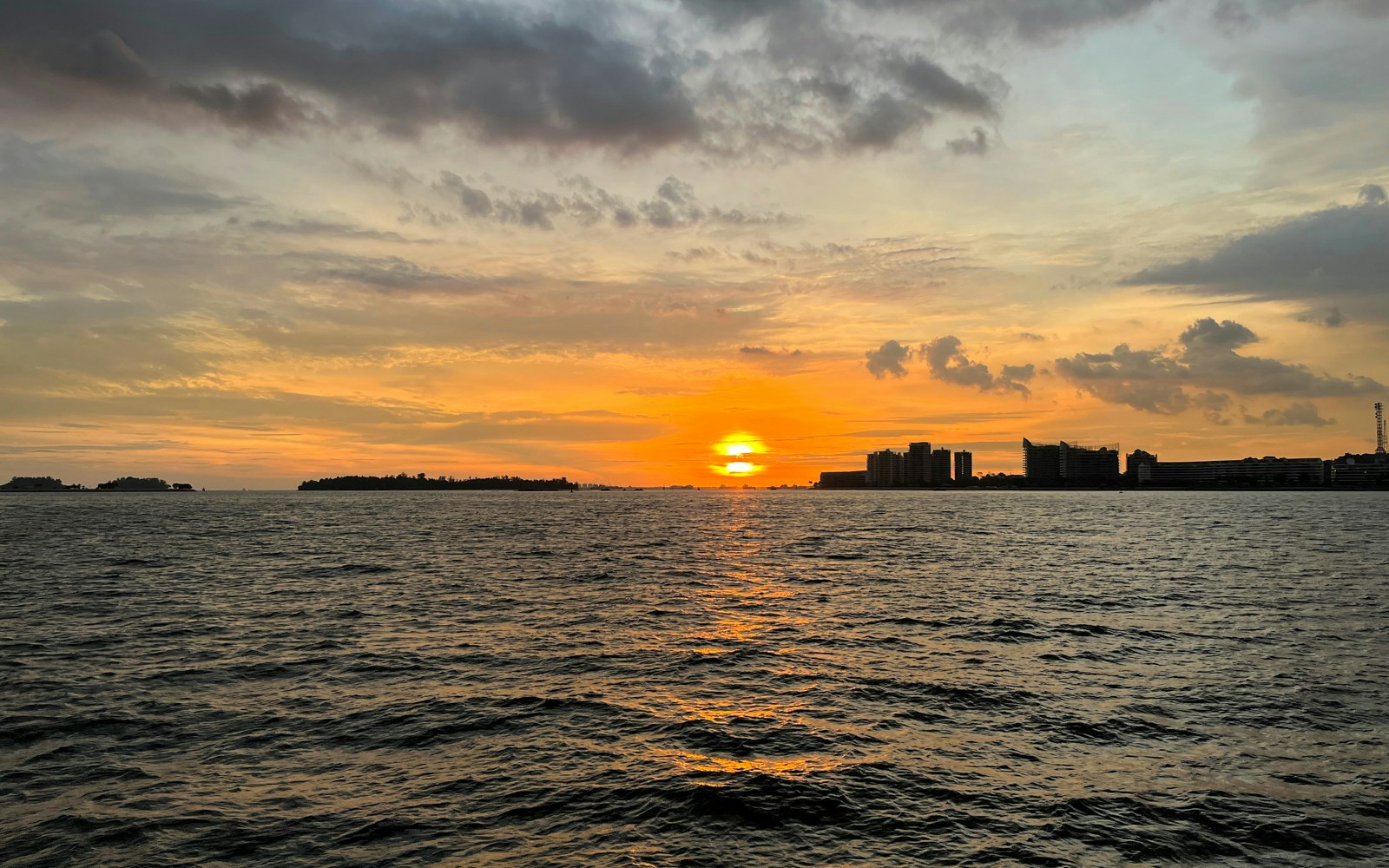 Sunset City Skyline Cruise with tourists enjoying BBQ on deck against a backdrop of city lights