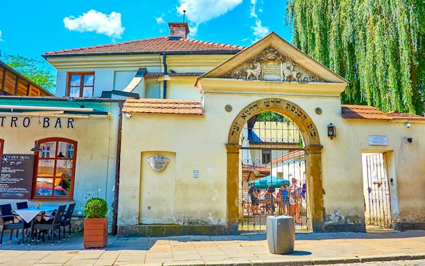 Entrance to Old Synagogue in Kazimierz, Krakow, with tourists gathered inside.