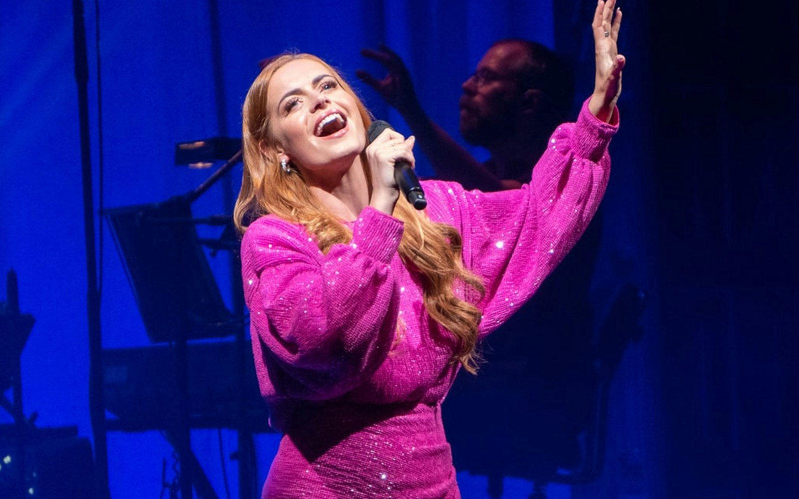 Singer performing on stage during West End musical love songs event.