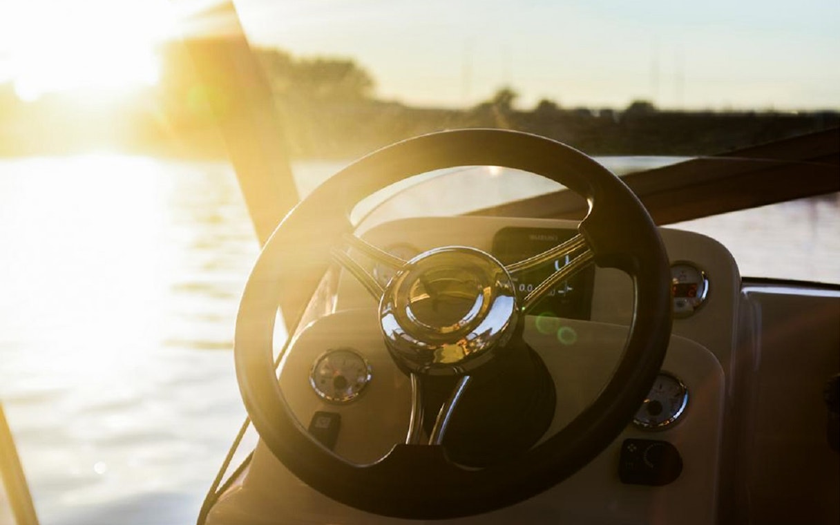 Boat steering wheel during sunset on Vistula River, Krakow tour.