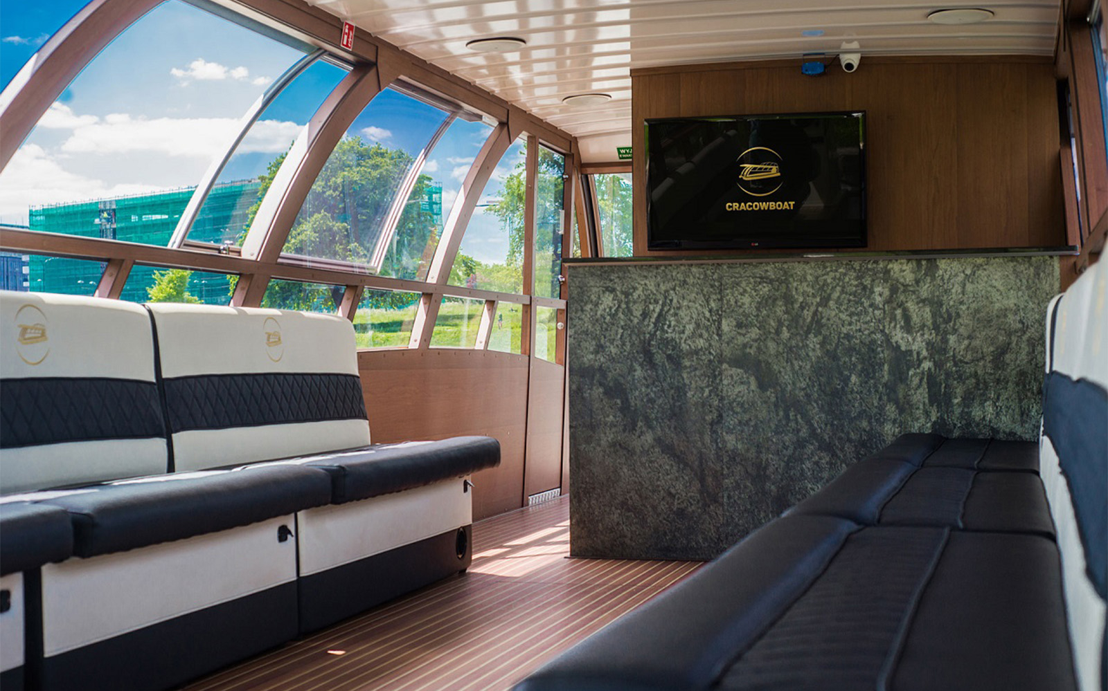 Interior of a modern boat on the Vistula River, Krakow, with seating and large windows.